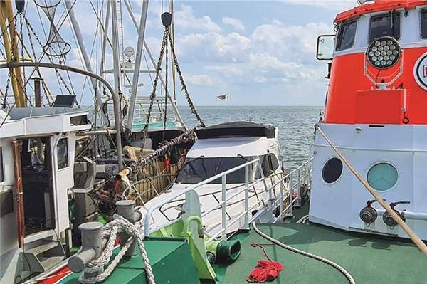 Fischer verhindern Untergang eines Motorbootes Der Seenotrettungskreuzer „Hermann Rudolf Meyer“ liegt längsseits am havarierten Motorboot, das zuvor von mehreren Fischkuttern vor dem Kentern gerettet worden war.