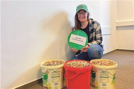 Norderneys Umweltmanagerin Sarah Wehrmaker mit drei Eimern voller Zigarettenkippen.